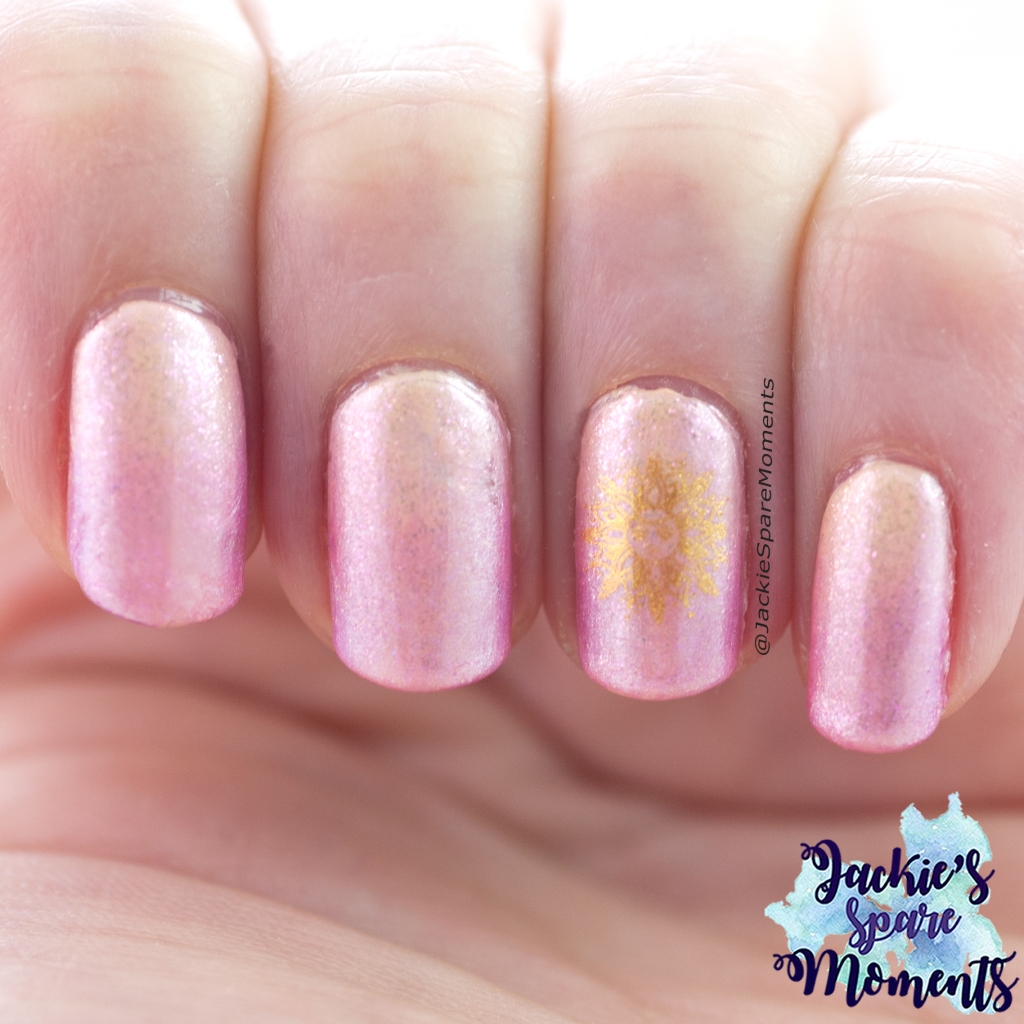 Nail art with yellow to pink gradient and stamped sun image in gold